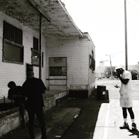 a black and white photo of a group of people standing in front of a building