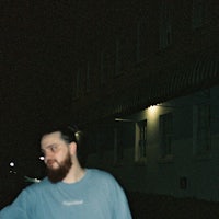 a man with a beard standing on a skateboard