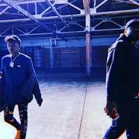 a man is walking with a skateboard in a warehouse